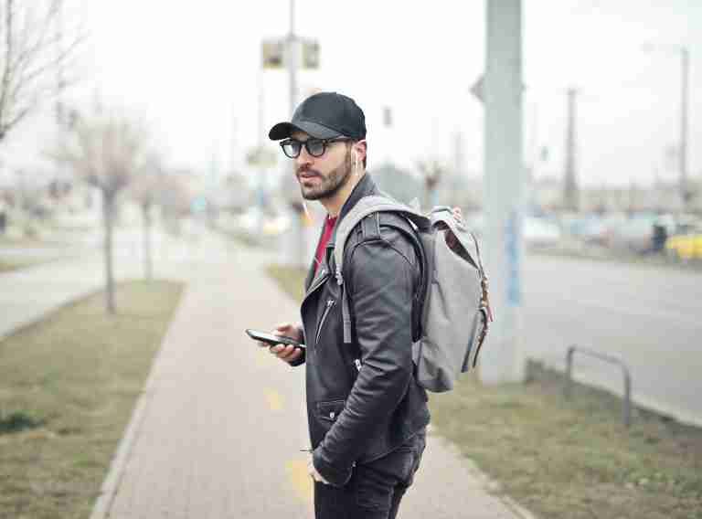 Man on a New York sidewalk with a hat and phone in hand googling, "Why is Dialectical Behavior Therapy So Effective?"