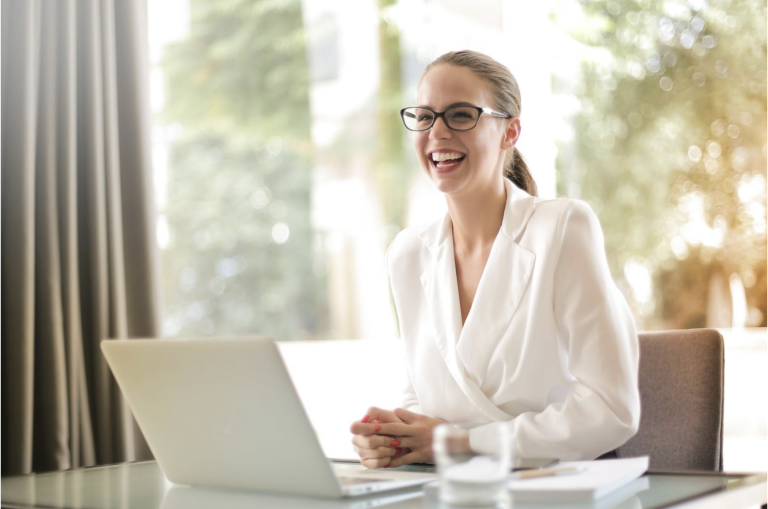 New York business woman dressed professionally while sitting in front of a computer where she's meeting with a online DBT therapist from Suffolk DBT.